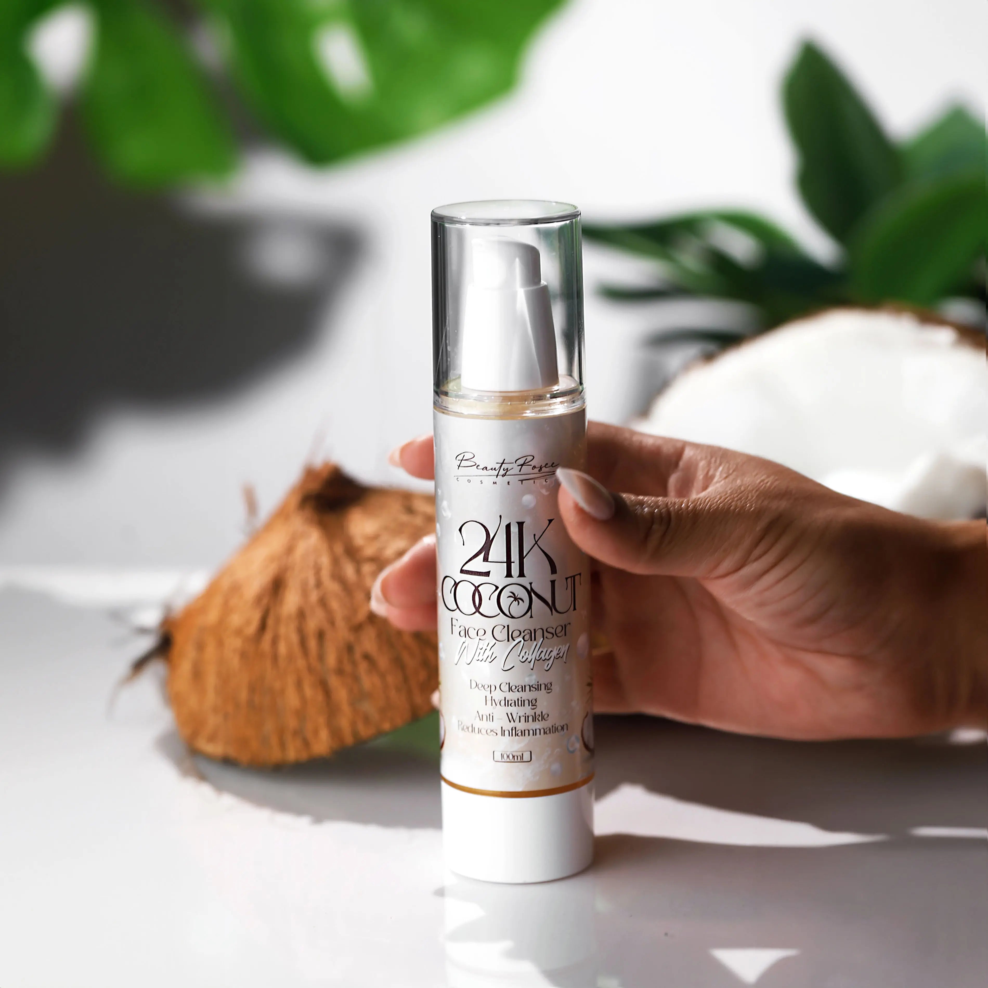 Hand holding 24K Coconut Face Cleanser, infused with gold and collagen for deep cleansing and hydration.