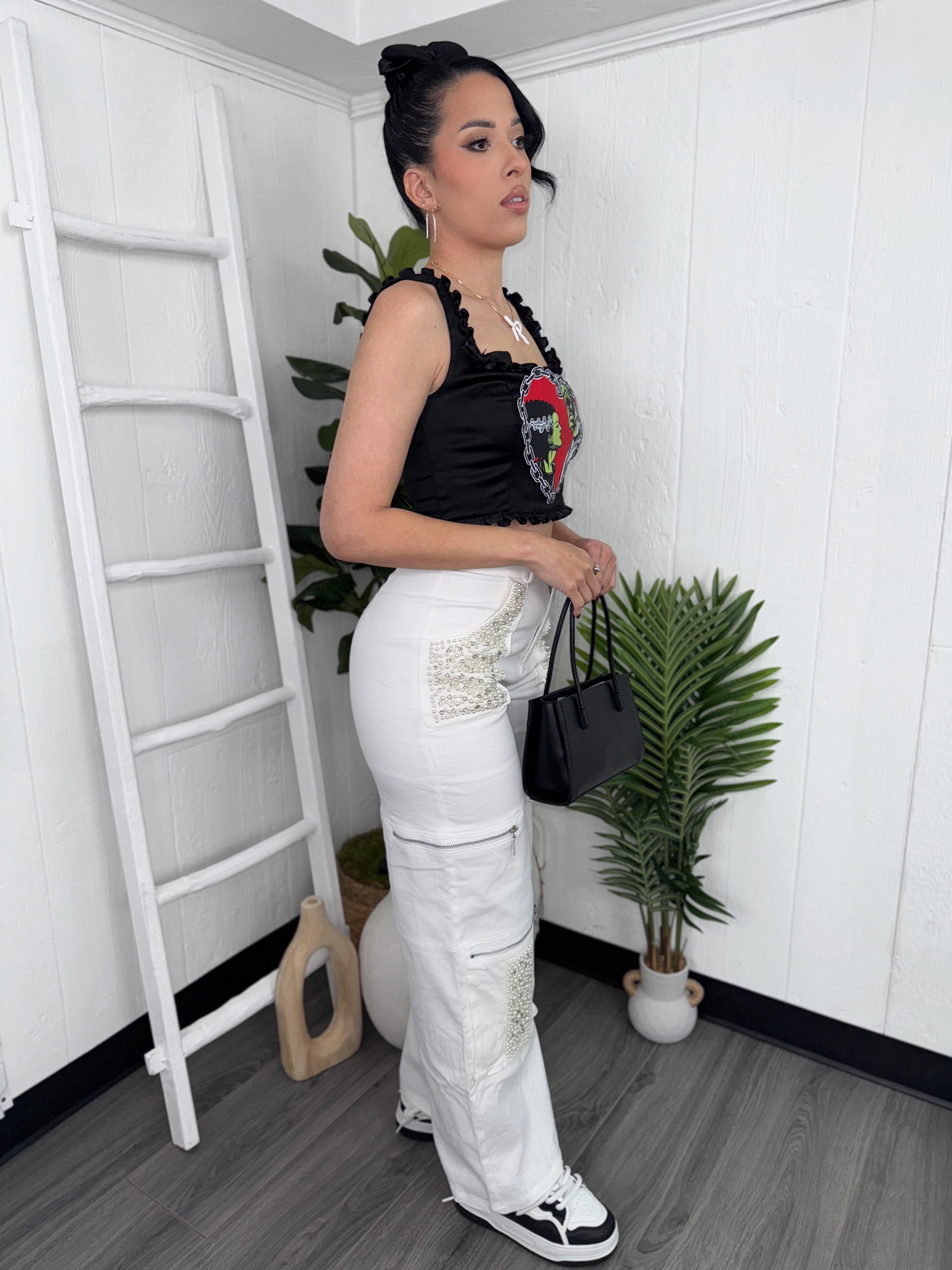 Model wearing pearl-embellished cargo jeans, featuring delicate rhinestones and a relaxed cargo fit.